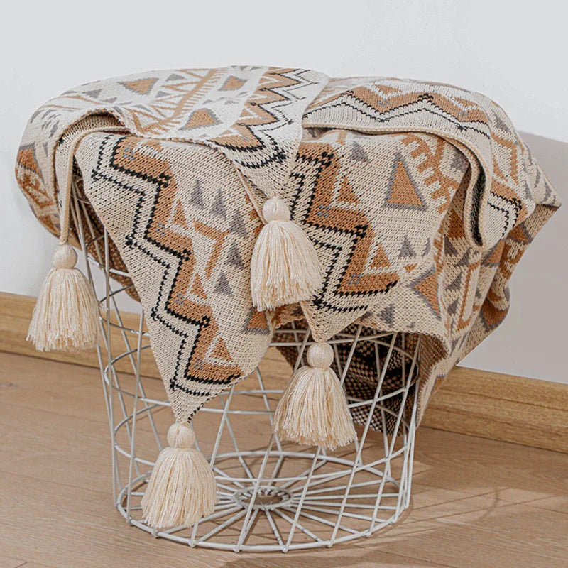 Gestrickte Quastenwurfdecke mit neutralem Streifenmuster und Boho-Akzenten