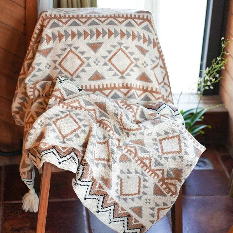 Gestrickte Quastenwurfdecke mit neutralem Streifenmuster und Boho-Akzenten