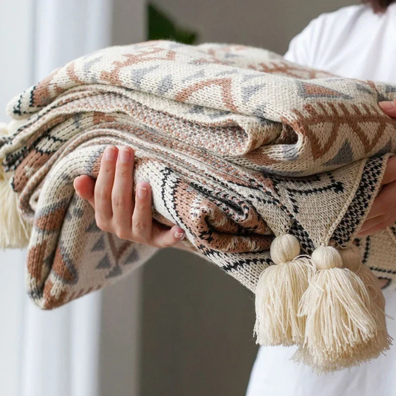 Gestrickte Quastenwurfdecke mit neutralem Streifenmuster und Boho-Akzenten