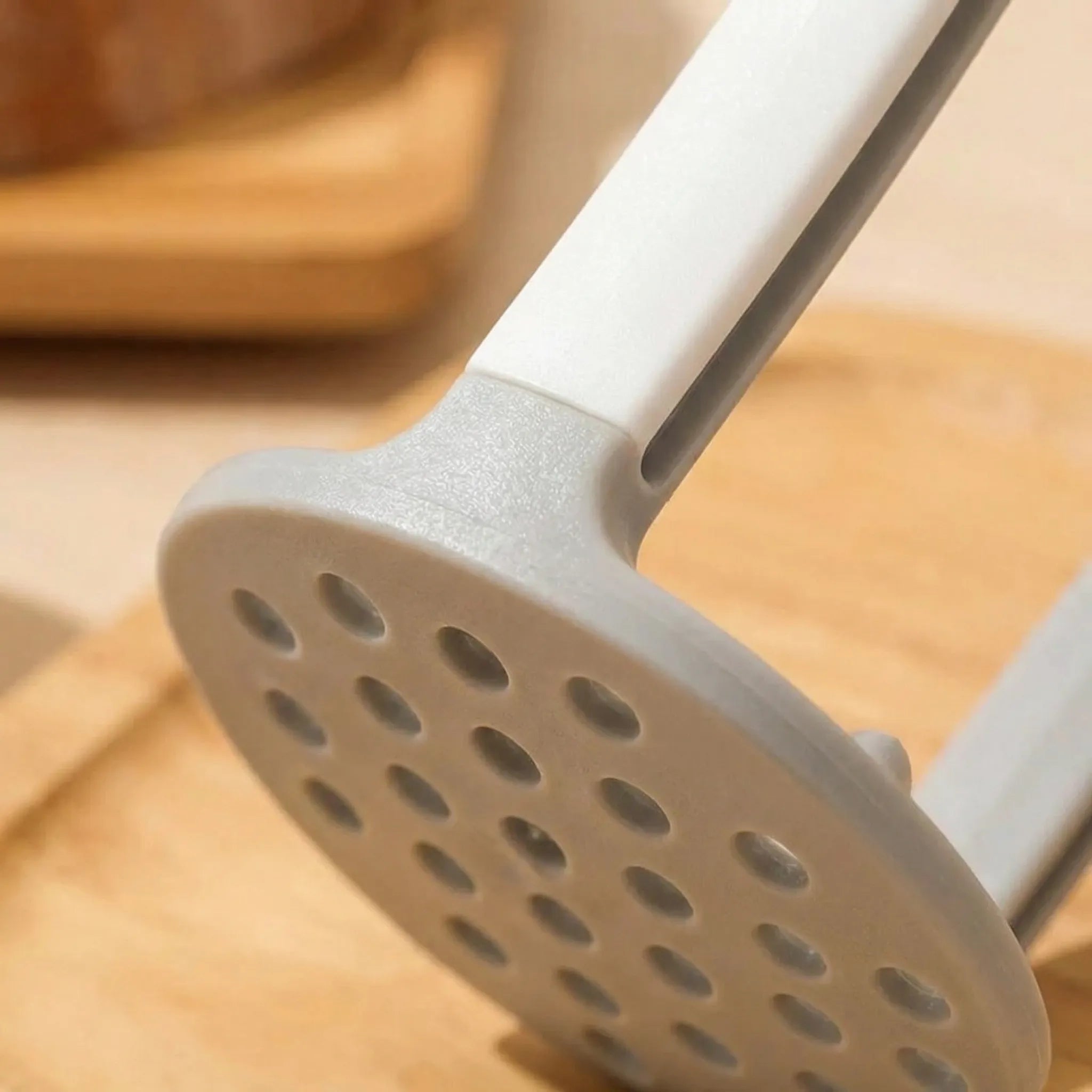 Kartoffelpresse mit rutschfestem Griff und gelöcherter Pressplatte