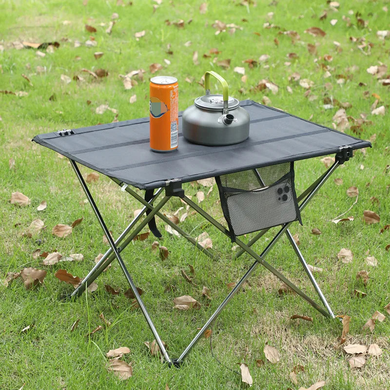 Klappbarer Campingtisch mit Kreuzbein-Rahmen und Netzwerktasche