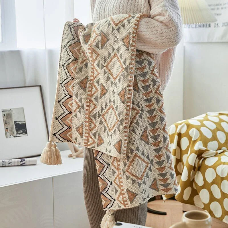 Gestrickte Quastenwurfdecke mit neutralem Streifenmuster und Boho-Akzenten