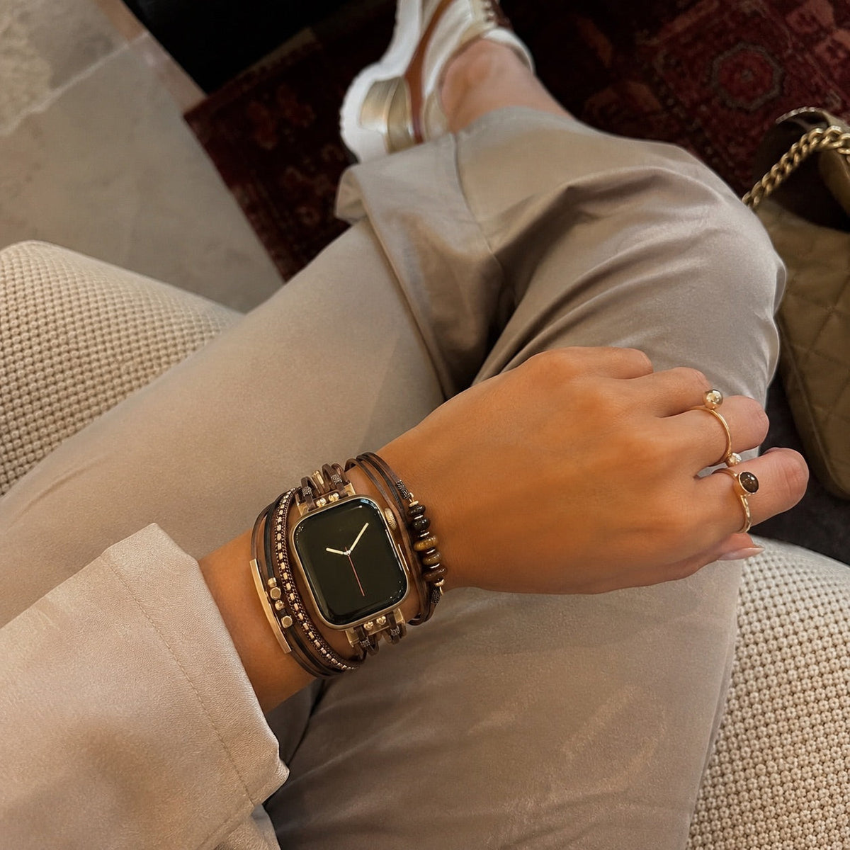 Damen-Uhrenarmband mit mehreren Kordeln, goldenen Details und grünen Steinen, elegantes Handgelenk-Accessoire